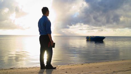 A man by the sea, holding the Bible in hand